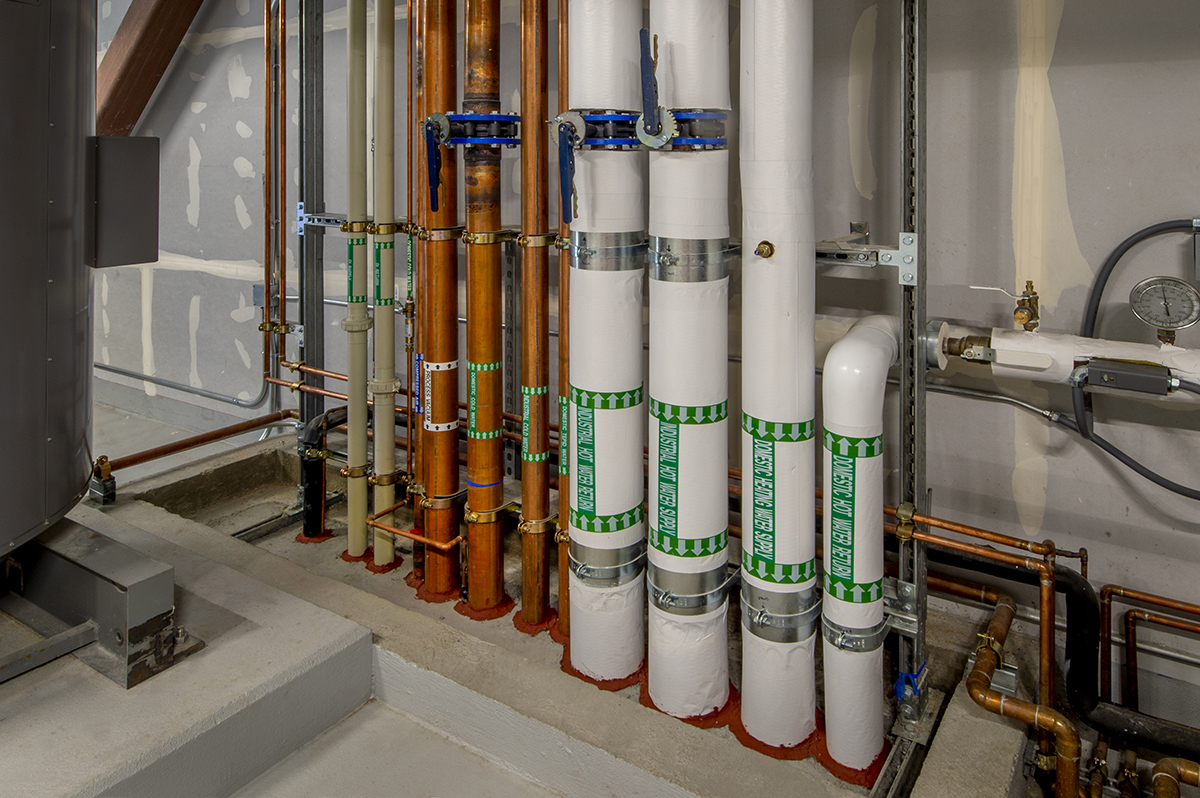 Boiler room with insulated pipes and fire stops.