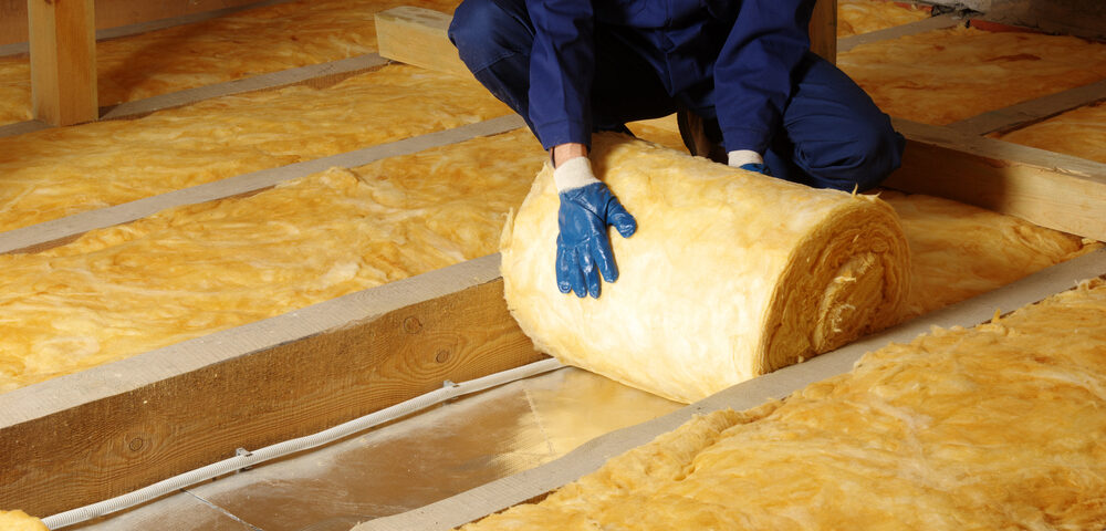 A closeup look at a worker removing insulation from an attic