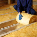 A closeup look at a worker removing insulation from an attic