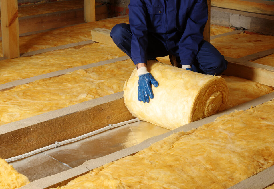 A closeup look at a worker removing insulation from an attic